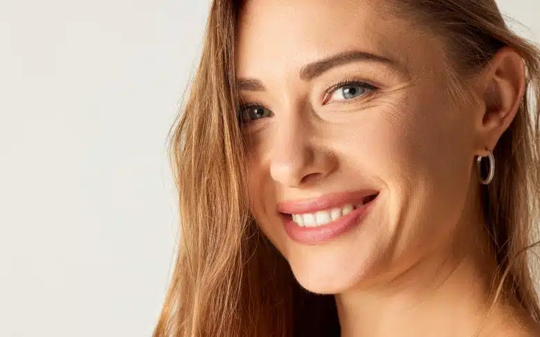 Jolie photo de profile face d une jeune femme souriante - nouveau dispositif medical au seon du cabinet prix t33 le traitement anti age de bio revitalisation | Dr Santini Paris 16