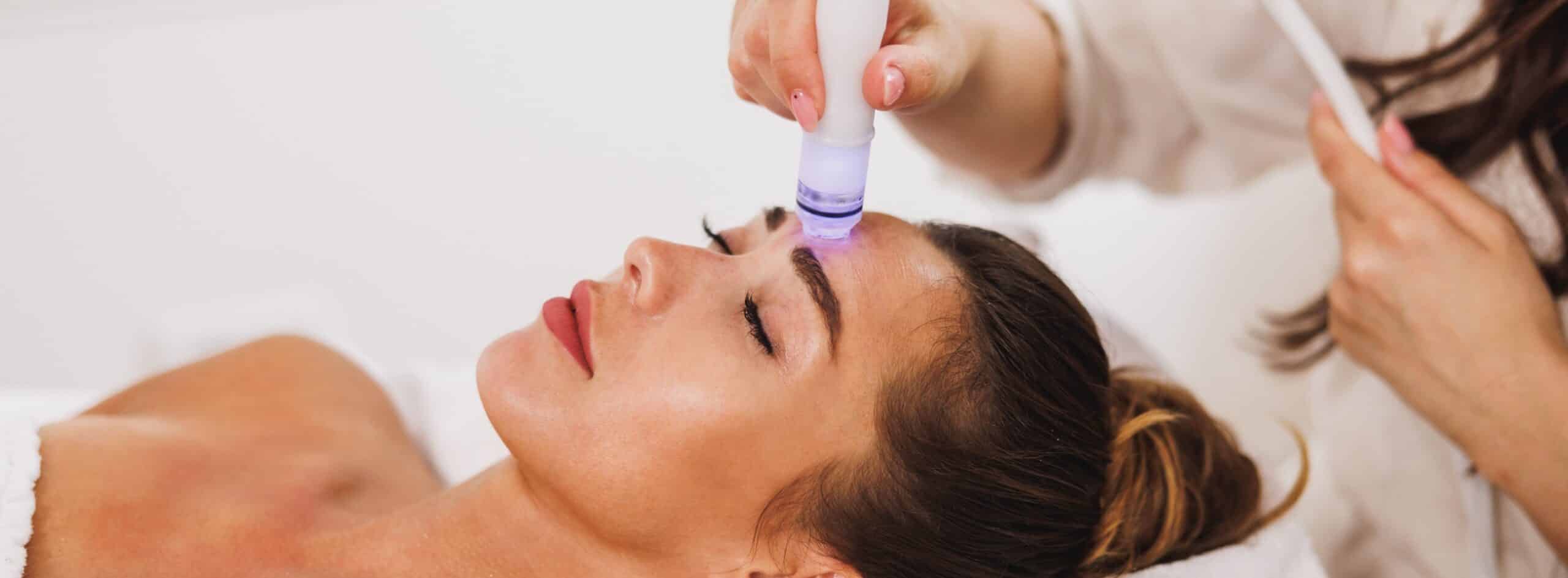 Jeune femme allongee recevant un soin esthetique sur son visage - decouvrez le soin revolutionnaire hydrafacial au sein du cabinet du Dr santini | Dr Santini Paris 16