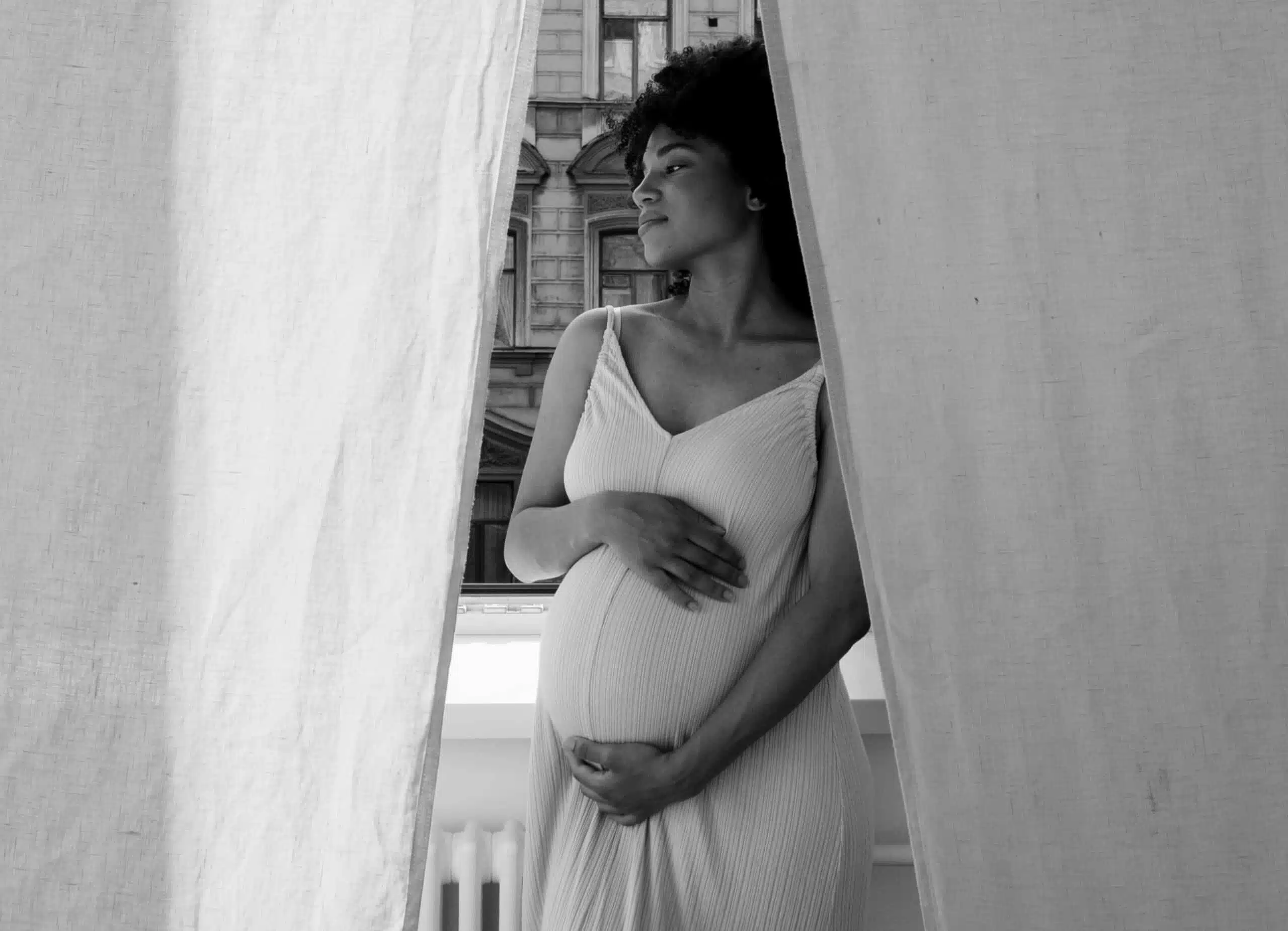 Stylized photo of a young pregnant woman holding her belly with her hands - mummy makeover | Dr Santini Paris 16