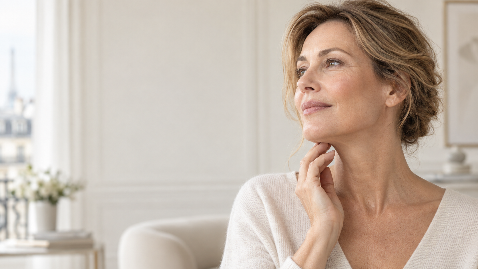 Femme mature touchant l’ovale de son visage et son cou avant un mini-lifting ou un lifting cervico-facial